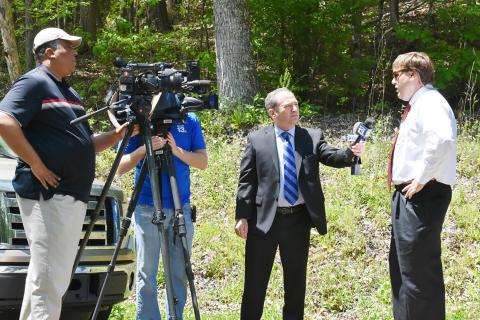 NBC 13 reporter Jeff Eliasoph is shown interviewing Andy Hamlin, chief assistant district attorney for the 24th judicial circuit, at the scene of the murders as an NBC 13 and a CBS 42 cameraman film the interview.
