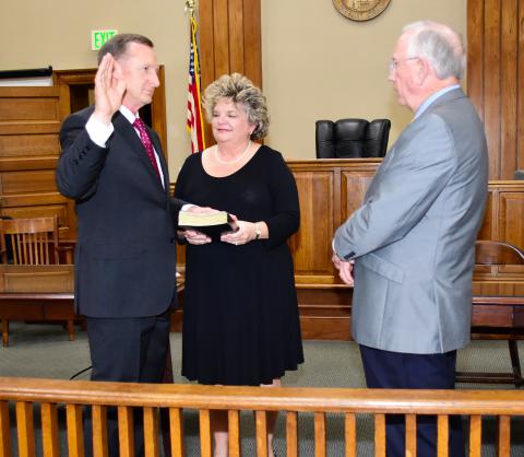 Probate Judge William Oswalt (right) is shown giving the oath of office to new Probate Judge Mike Freeman as his wife Tonya Freeman watches during a ceremony held on Jan. 11 in the courtroom of the Fayette County Courthouse.