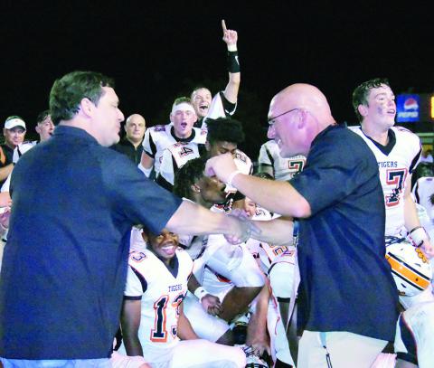 Shown is Coach Bill Smith (right) being congratulated by FCHS Principal Dr. Jeremy Madden after the Tigers defeated Winfield.