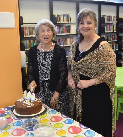 Toni Robertson (left) and Carolyn Junkin are shown cutting the Progress Club’s 100th anniversary cake.