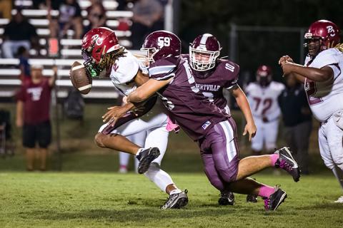 Hub’s Ronnie Minor (59) and Zeb Haley (10) team up to take down a Tornadoes’ offensive player. | Photo by Leah Hollingsworth