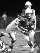 Isaac Darty (34) is pictured running for a good gain against South Lamar.