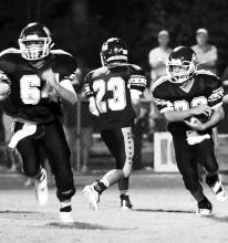 Aaron Cribb (64) blocks as Gage Key (36) carries the ball for Hubbertville against Berry.