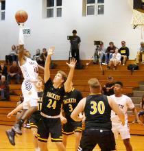 Darius Loyd (13) jumps high as he scores a basket over four Corner defenders.