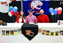 Shown at the signing, from left: Jennifer Sanford (mom), Carter Sanford and Brandon Sanford (dad).
