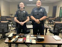 Pictured (L to R) are Officers Taylor Kelly and Kris Parsons with the items seized during the traffic stop on May 4. 