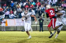 Hub’s Tyler Stricklin (7) rushes the ball past a Bulldogs’ defender. | Photo by Leah Hollingsworth