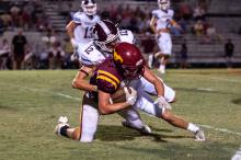Hubbertville’s Trevor Benton carries the ball as a South Lamar defender makes the tackle during the Lions’ 28-13 region victory Friday night.
